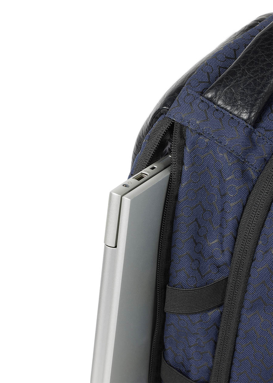 Side view of the Kerrits EQ Backpack in navy, displaying the streamlined silhouette and additional side laptop pockets.