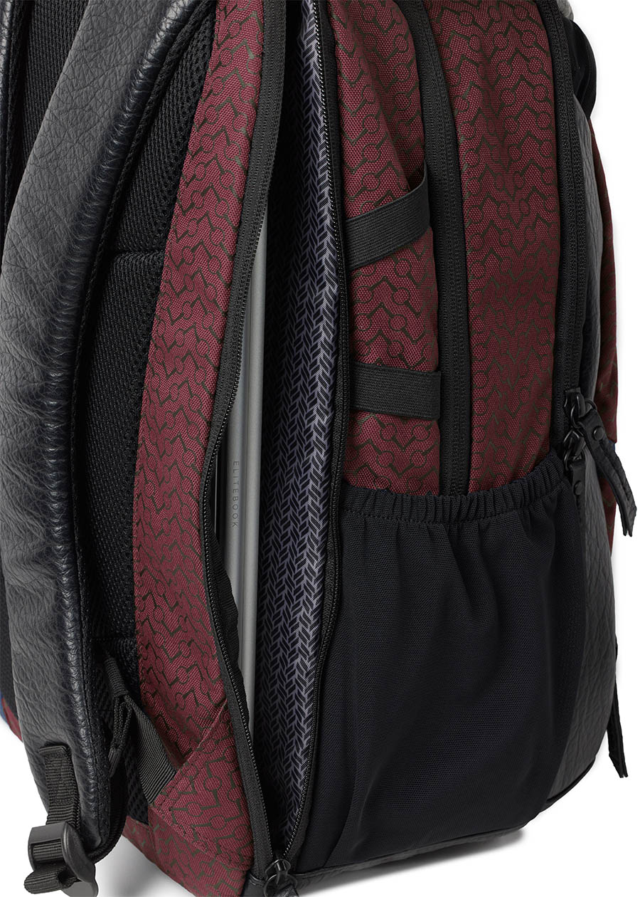 Side view of the Kerrits EQ Backpack in Burgundy, displaying the streamlined silhouette and additional side laptop pockets.