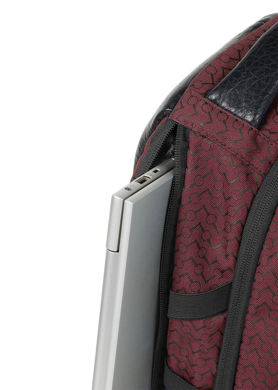Side view of the Kerrits EQ Backpack in burgundy, displaying the streamlined silhouette and additional side laptop pockets.