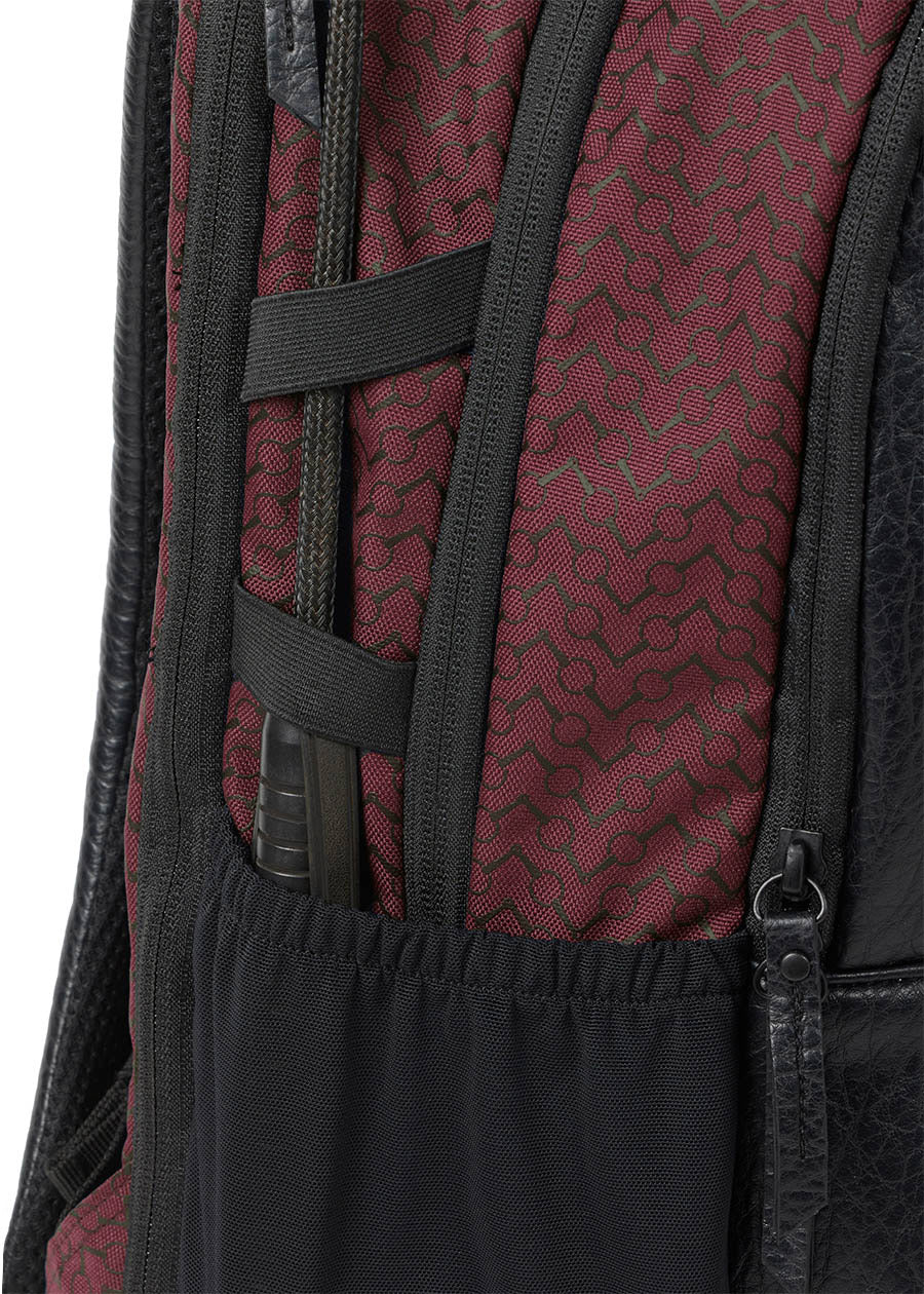 Detailed view of the side of Kerrits EQ Backpack fabric in Burgundy, highlighting the riding crop holder.
