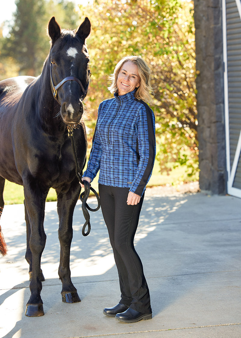 Rider leading a horse while dressed in Kerrits Microcord™ Knee Patch Pocket Tight, illustrating the pant's ergonomic design and practicality at the barn.