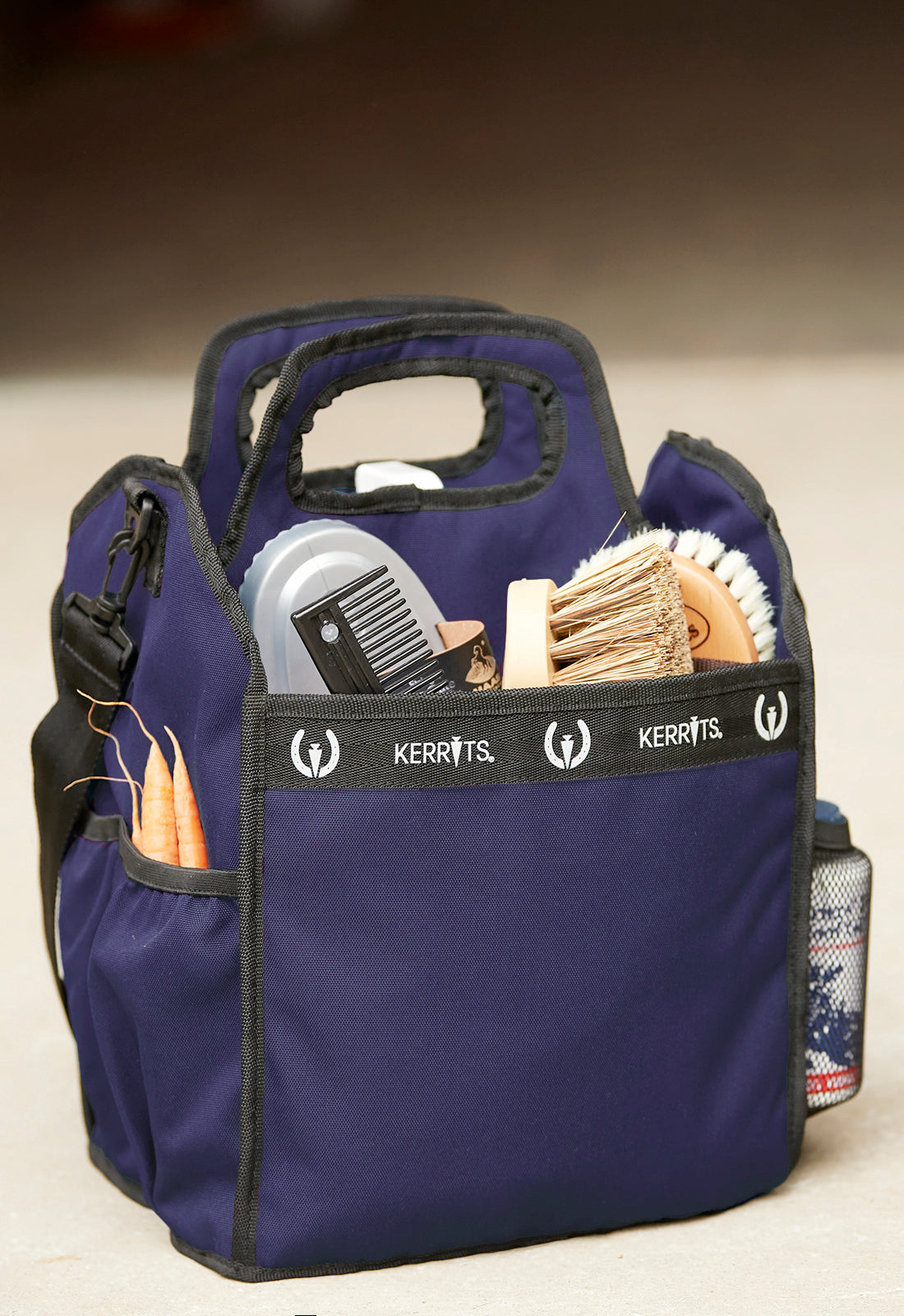 Kerrits Barn Caddy placed on a stable floor, filled with grooming supplies, ready for use.