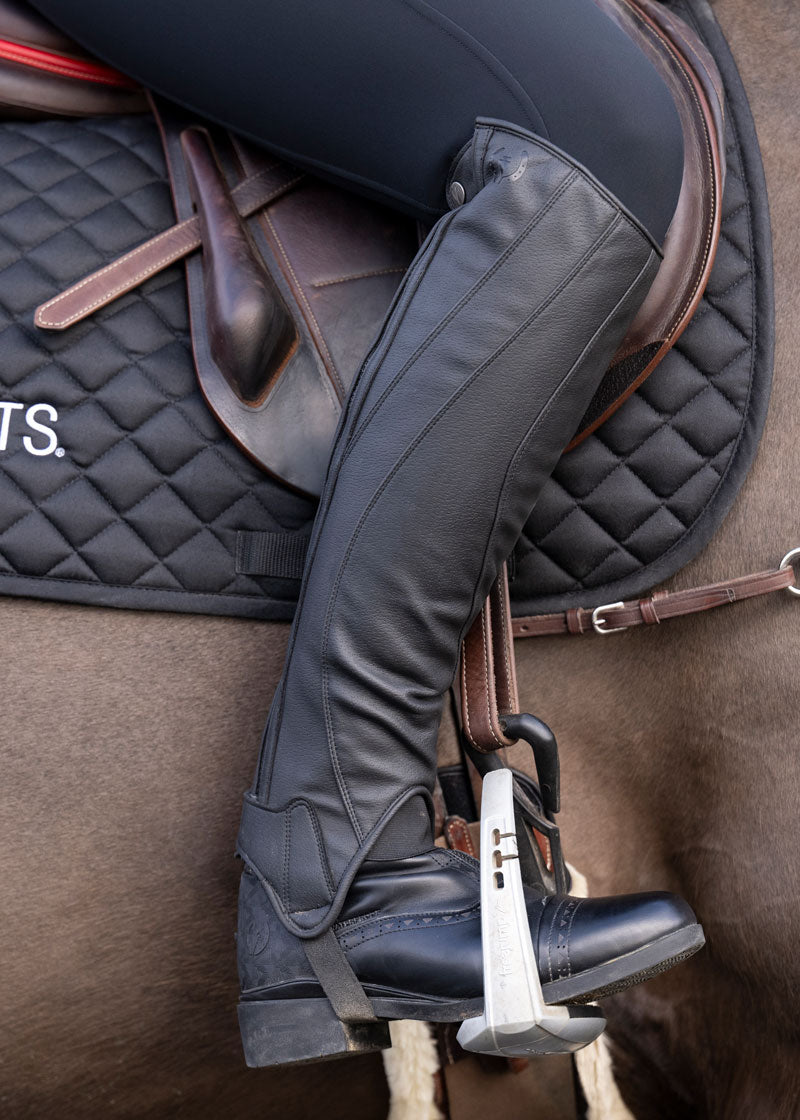 Equestrian sporting the Kerrits GripTek™ Half Chap 2.0 during an outdoor ride, highlighting the half chap's performance in various weather conditions.