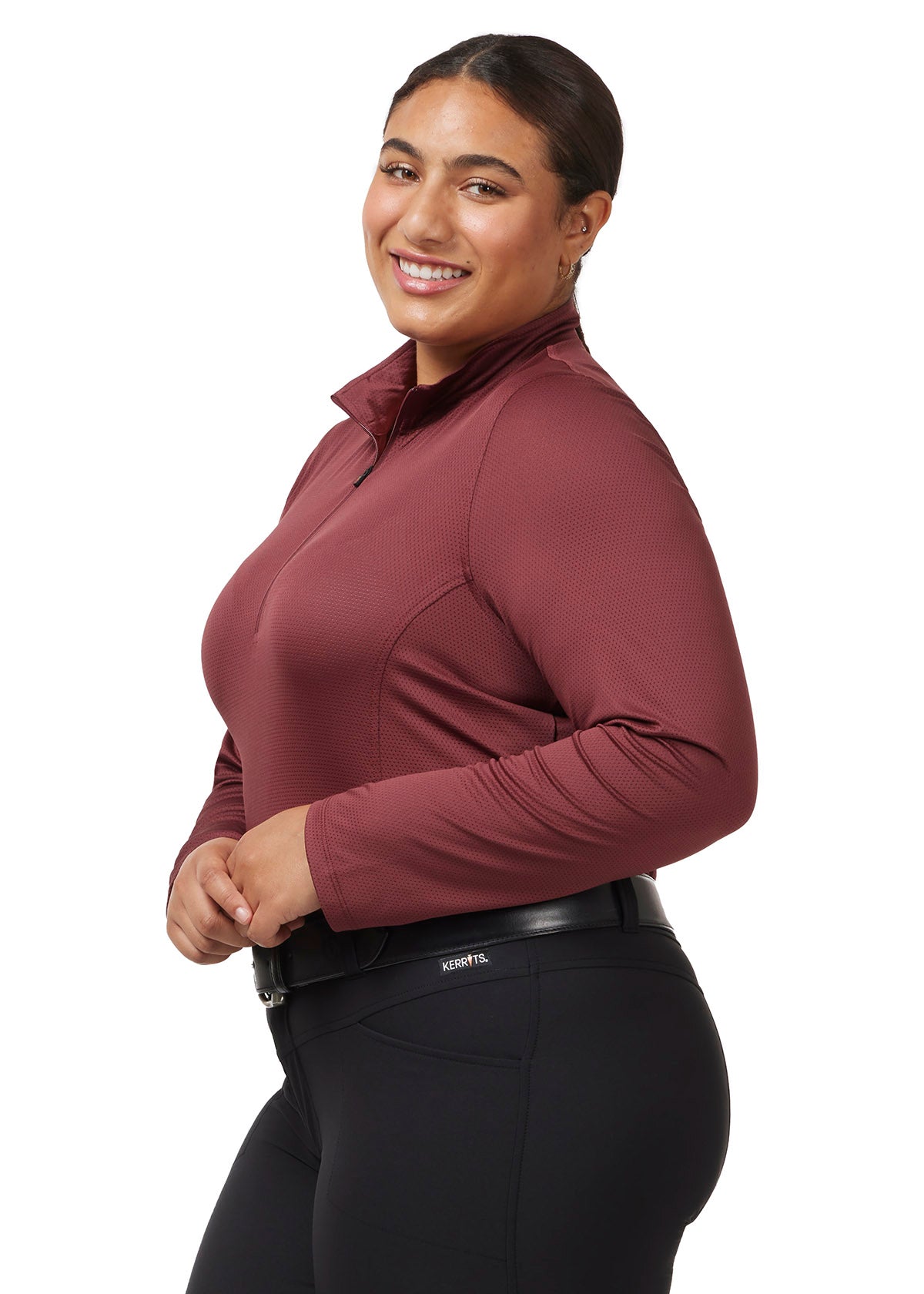 ide profile of a model wearing the Kerrits Ice Fil® Lite Long Sleeve Riding Shirt in Burgundy, showcasing the ergonomic seams and long sleeves.