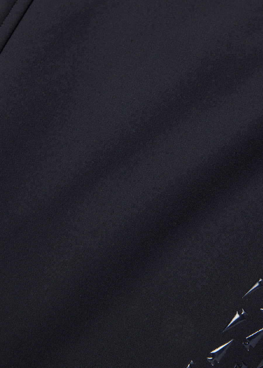 Closeup of the smooth black climalux stretch-woven fabric, which sheds water and blocks wind for a warm ride.