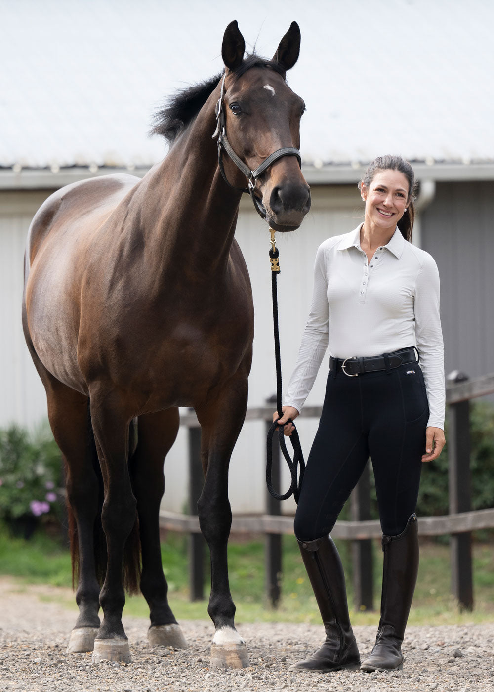 Rider wearing the Flex Lite Knee Patch Riding Tight while leading a horse, illustrating its versatility for both riding and groundwork.