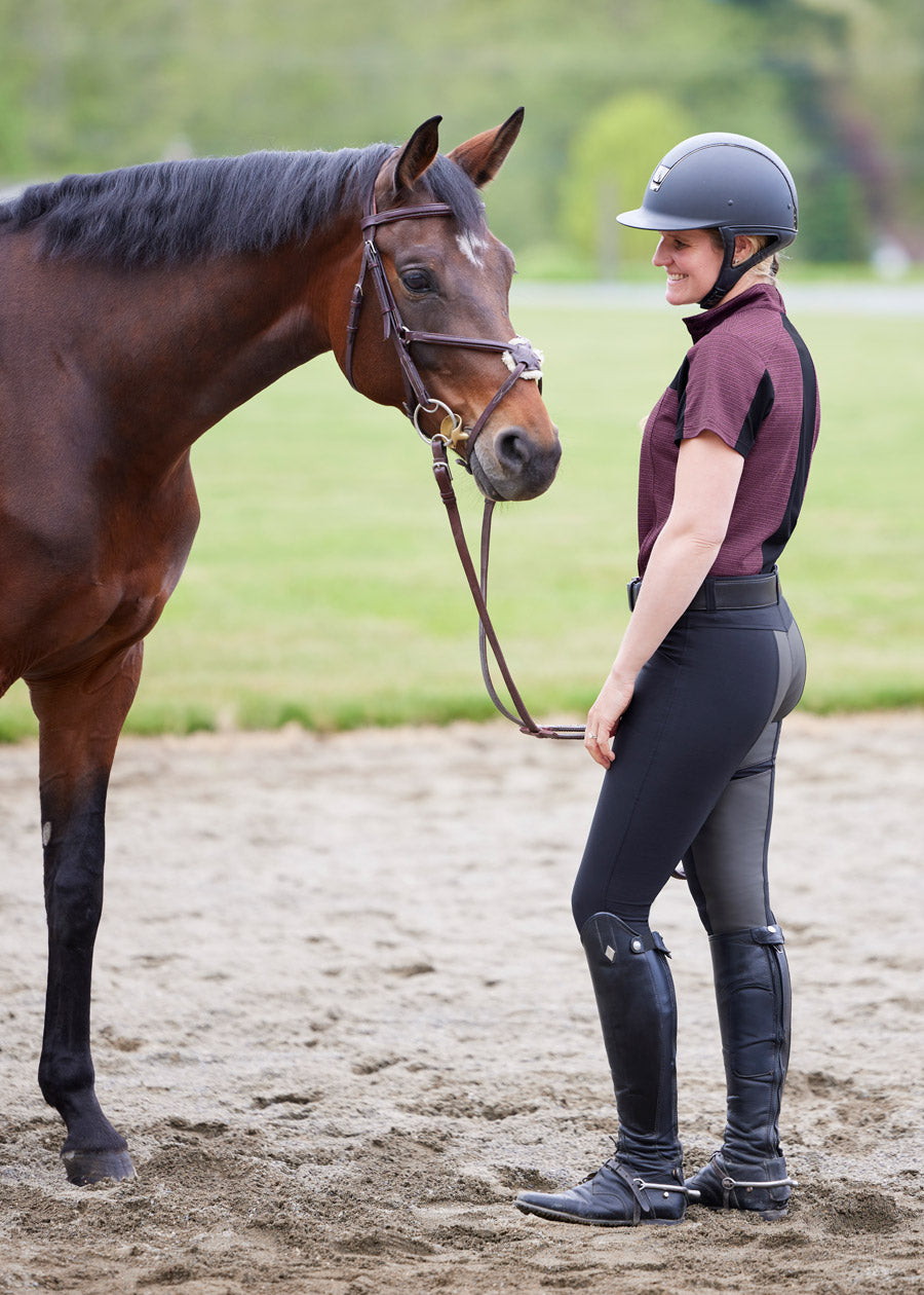 Side profile of a model wearing the Crossover II® Full Seat Riding Breech in Black, highlighting the fitted silhouette and water-resistant fabric.