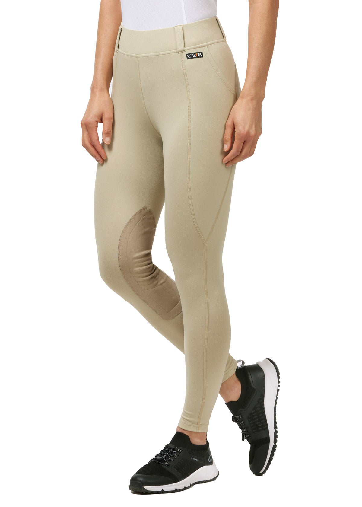 Model wearing the Performance Knee Patch Pocket Riding Tight in Tan, highlighting the front fit and waistband.