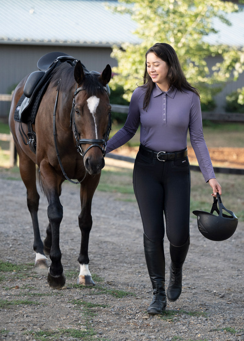 Equestrian leading a horse while wearing the Kerrits K-Flex™ Full Seat Breech, emphasizing comfort for groundwork.