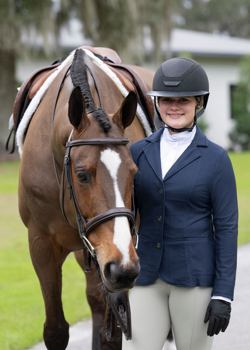 Rider posing with a horse, wearing the show coat, capturing the essence of youthful equestrian enthusiasm and style