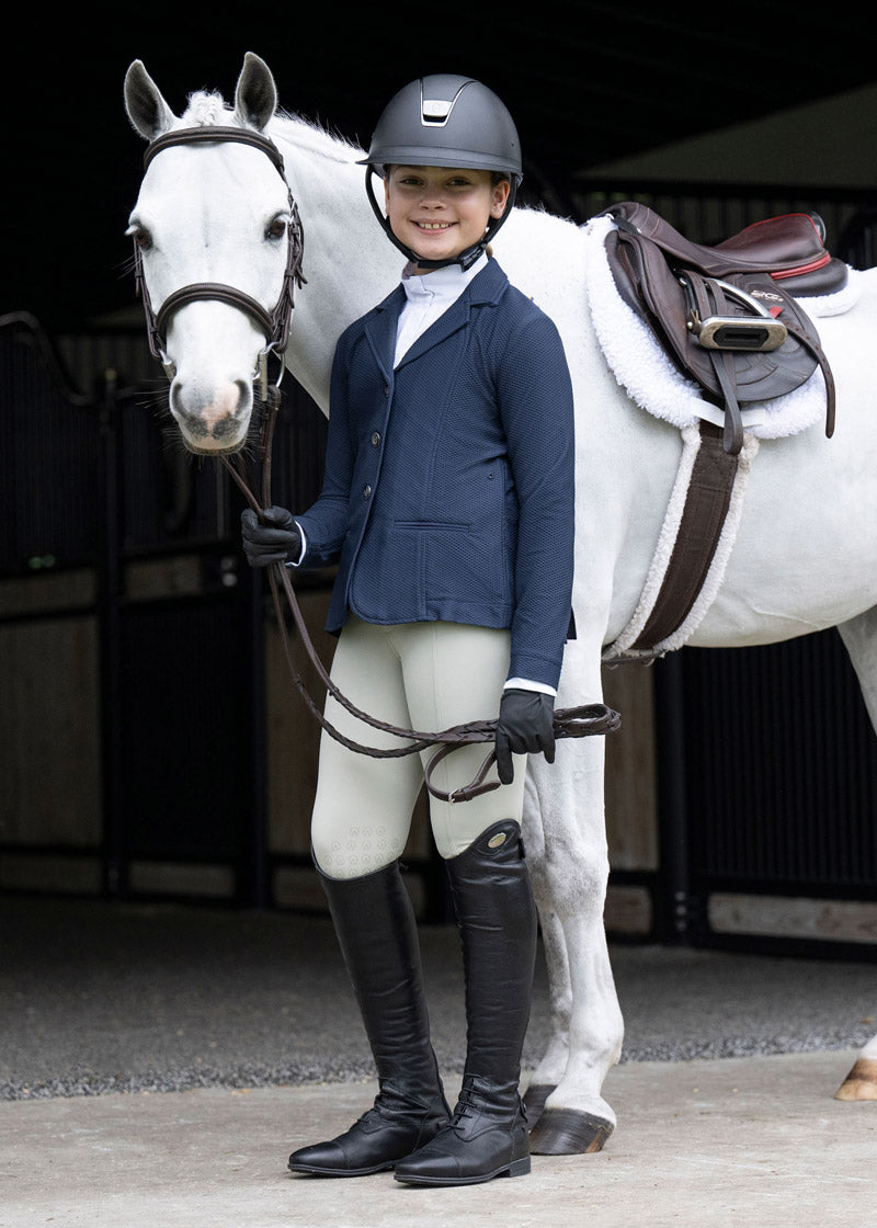 Rider posing with a horse, wearing the show coat, capturing the essence of youthful equestrian enthusiasm and style
