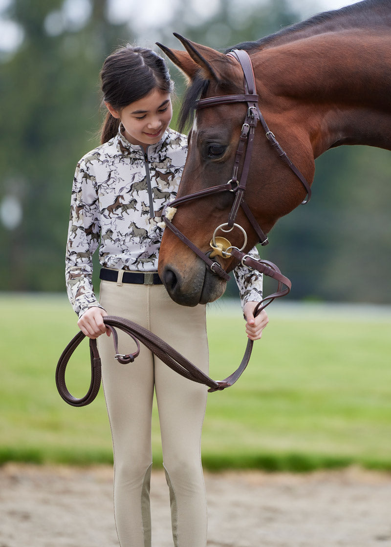 Rider standing beside a horse, dressed in the Microcord™ Knee Patch Riding Tight, highlighting the professional and stylish appearance suitable for competitions
