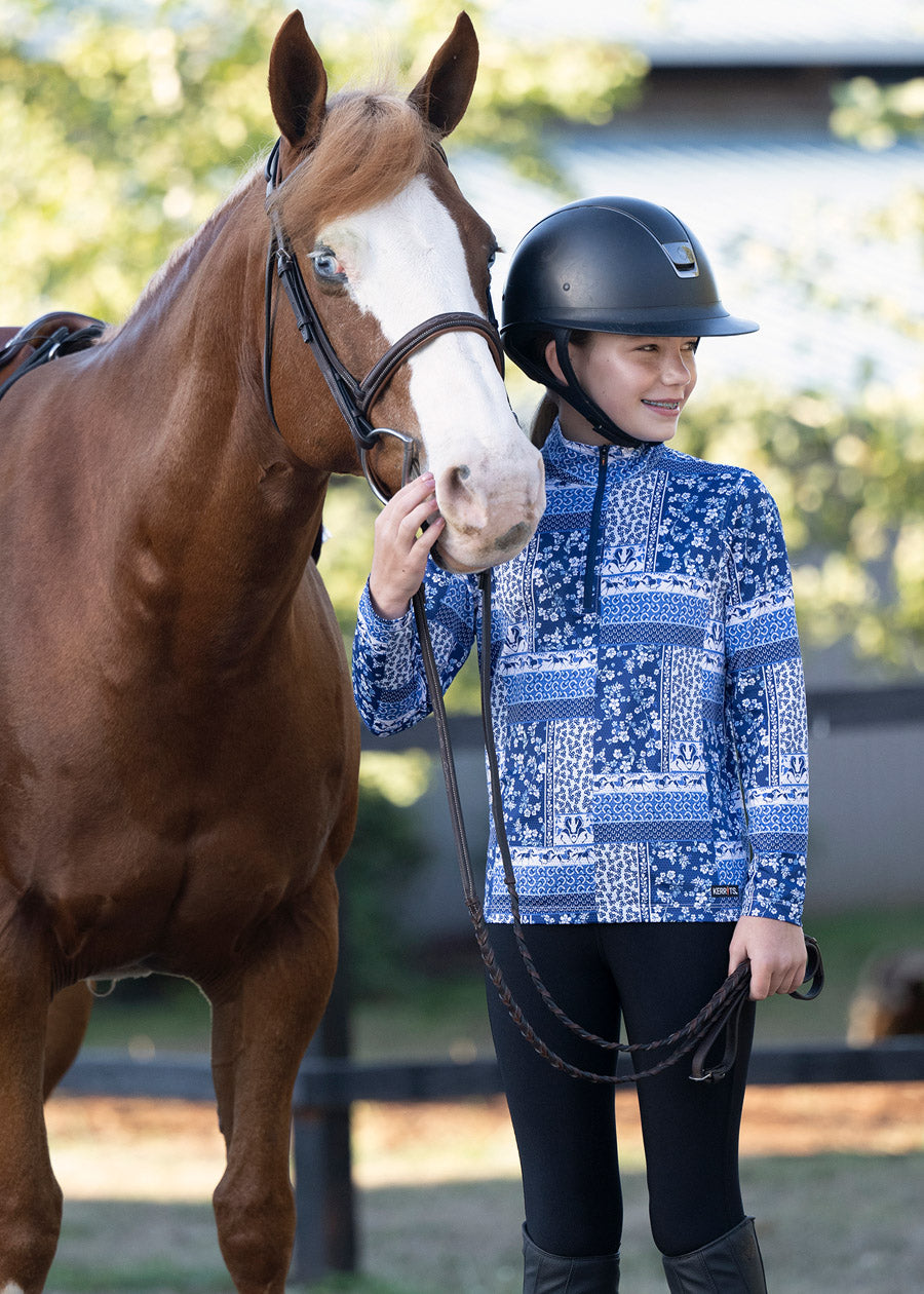 Rider standing beside a horse, dressed in the shirt, highlighting the blend of performance and style suitable for various equestrian activities