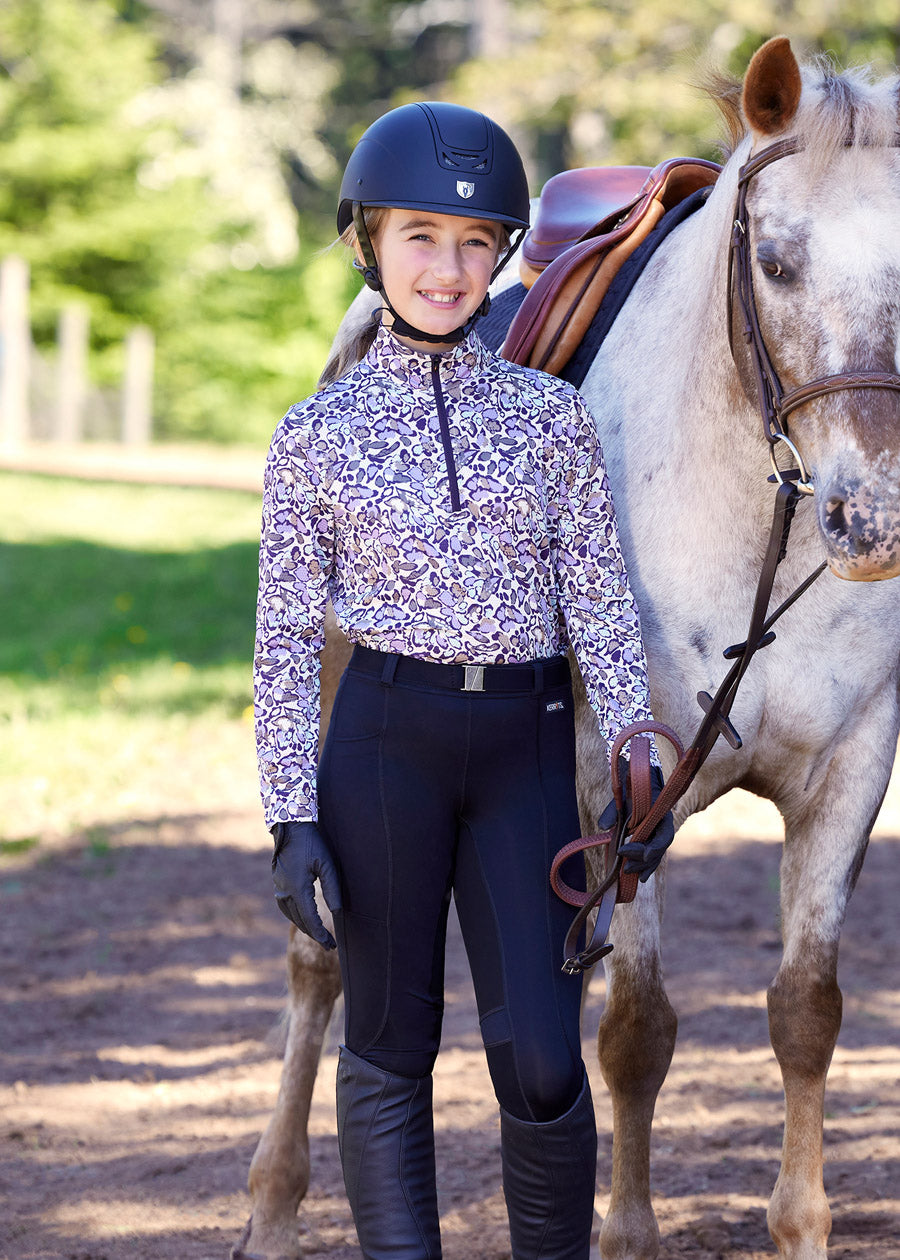 Rider standing beside a horse, dressed in the shirt, highlighting the blend of performance and style suitable for various equestrian activities