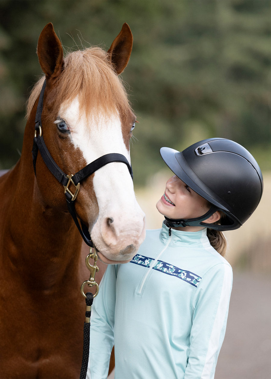 Rider standing beside a horse, dressed in the shirt, highlighting the blend of performance and style suitable for various equestrian activities