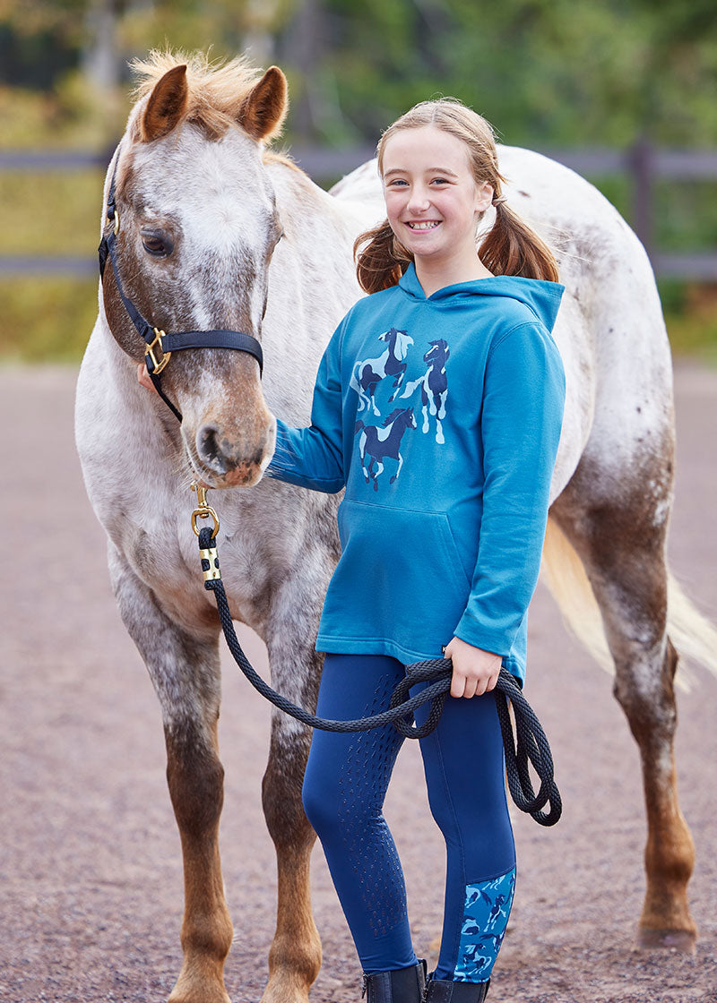 Child wearing the tights during a barn activity, showcasing their versatility and durability in various equestrian settings