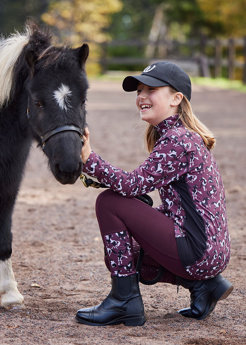Child wearing the tights during a barn activity, showcasing their versatility and durability in various equestrian settings