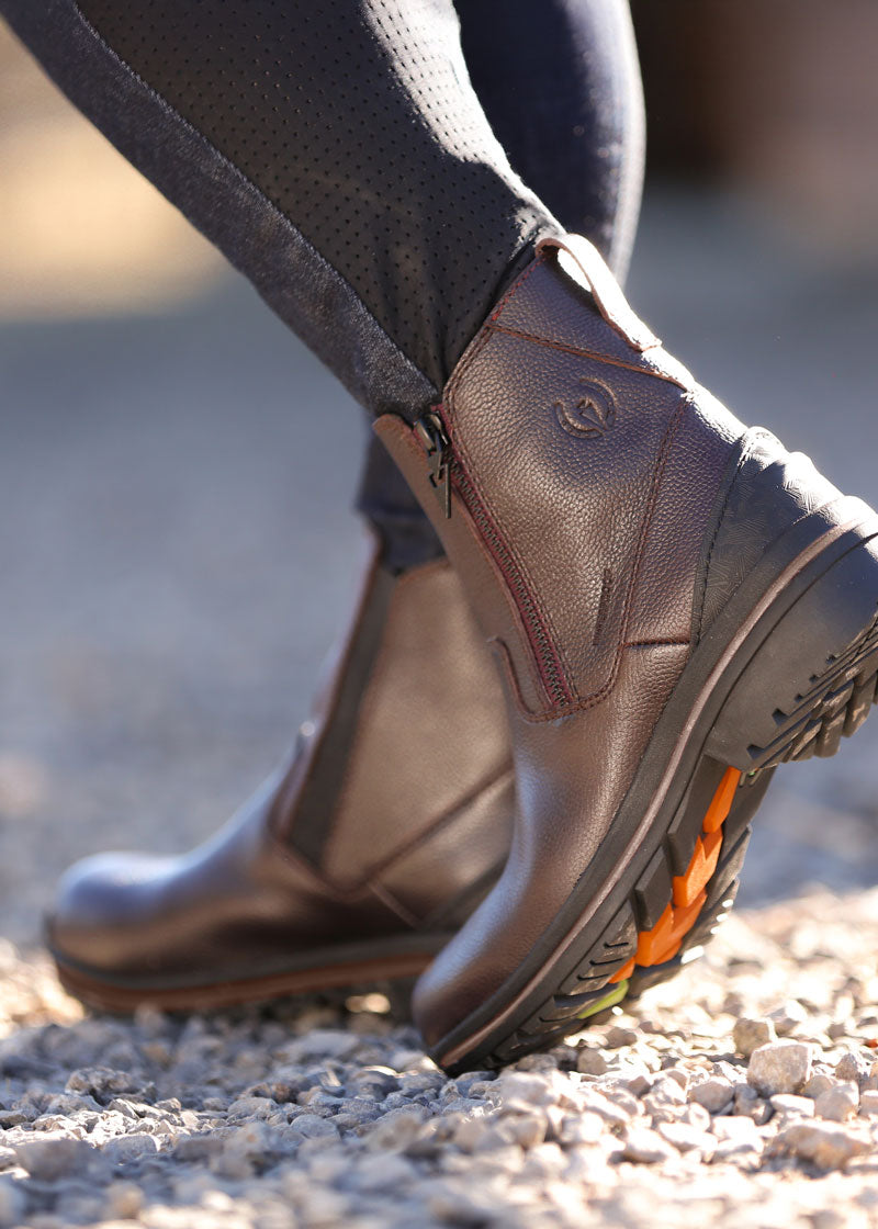 Individual walking through barnyard in Woodstock Waterproof Barn Boot