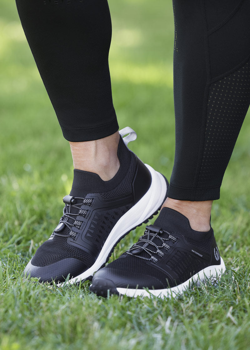 Equestrian sporting the Groundwork Waterproof Sneakers during a morning walk, highlighting its versatility outside of the barn.