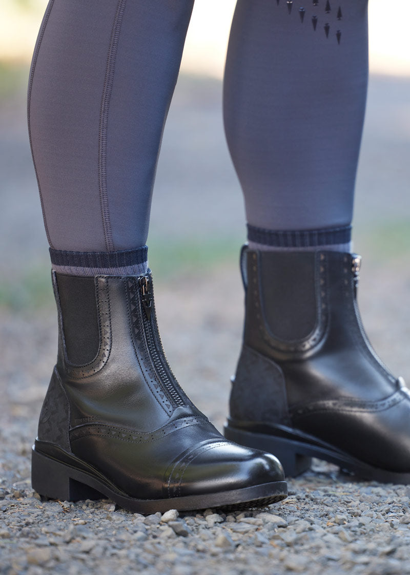Equestrian rider wearing Kerrits Essence Waterproof Paddock Boot while at the barn.