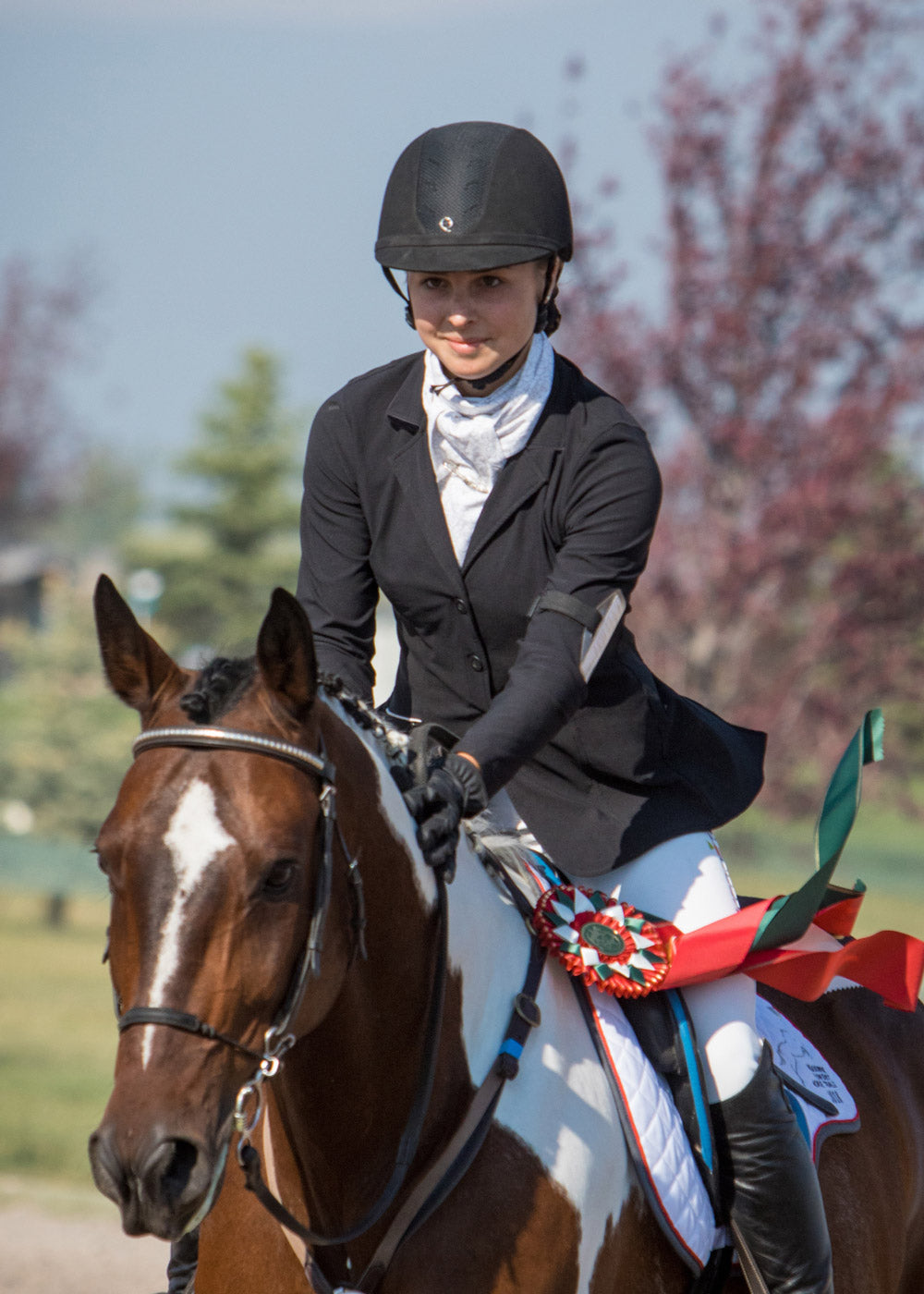 Equestrian wearing the Stretch Competitor Koat while riding, demonstrating the coat's flexibility and elegant appearance in the saddle