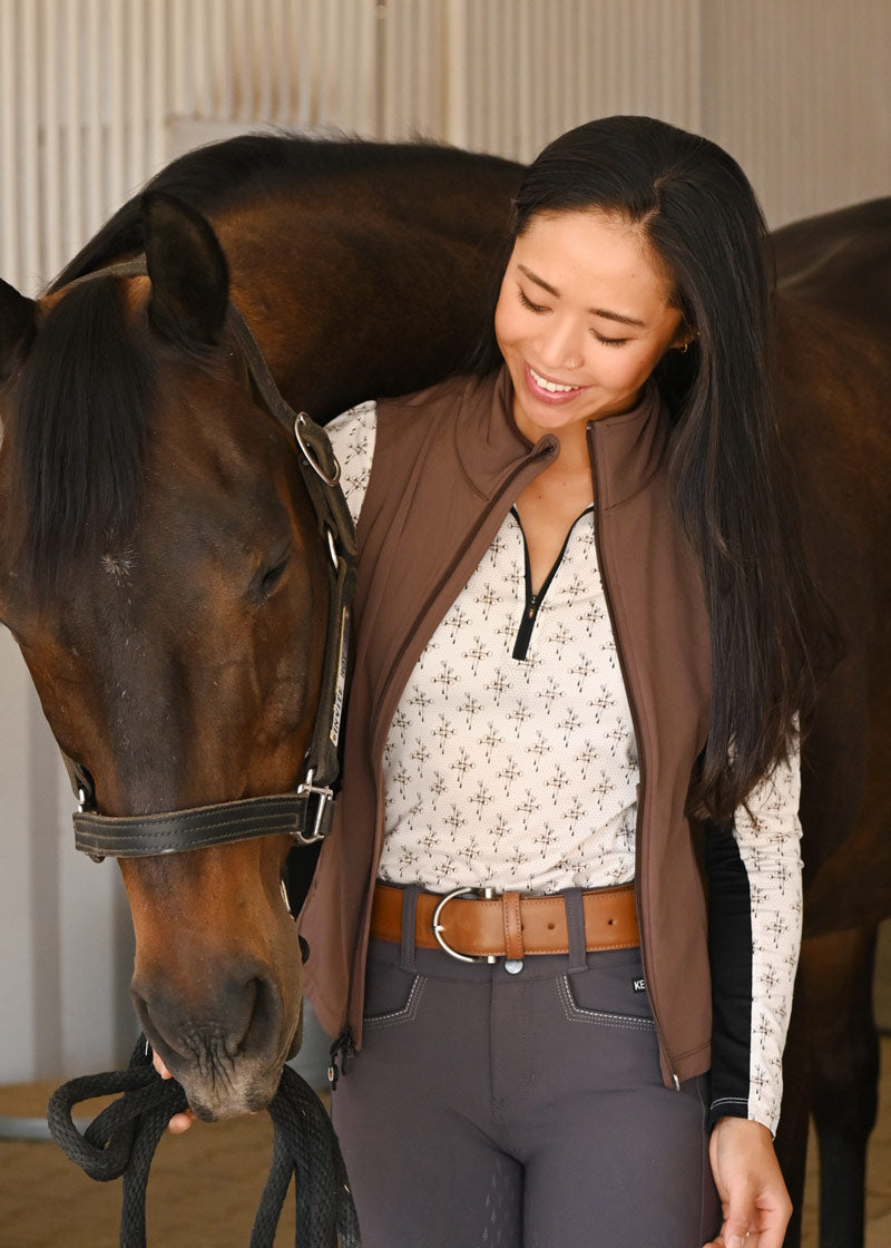 Equestrian wearing the Simple D Leather Belt while at the barn, highlighting its durability and practicality