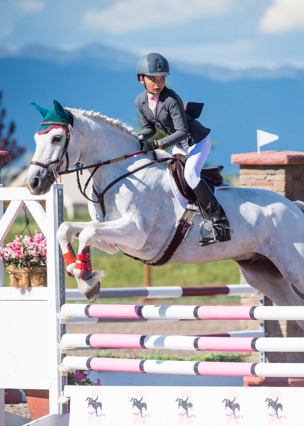 Young rider wearing the Crossover II® Knee Patch Breech while riding, demonstrating the functional design and comfortable fit