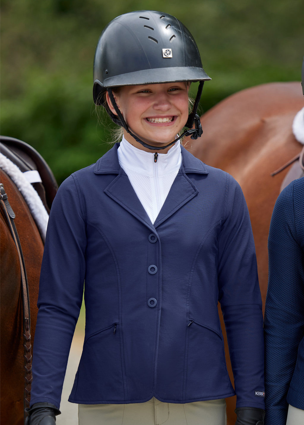 Child standing beside a horse, wearing the coat, showcasing its suitability for equestrian events