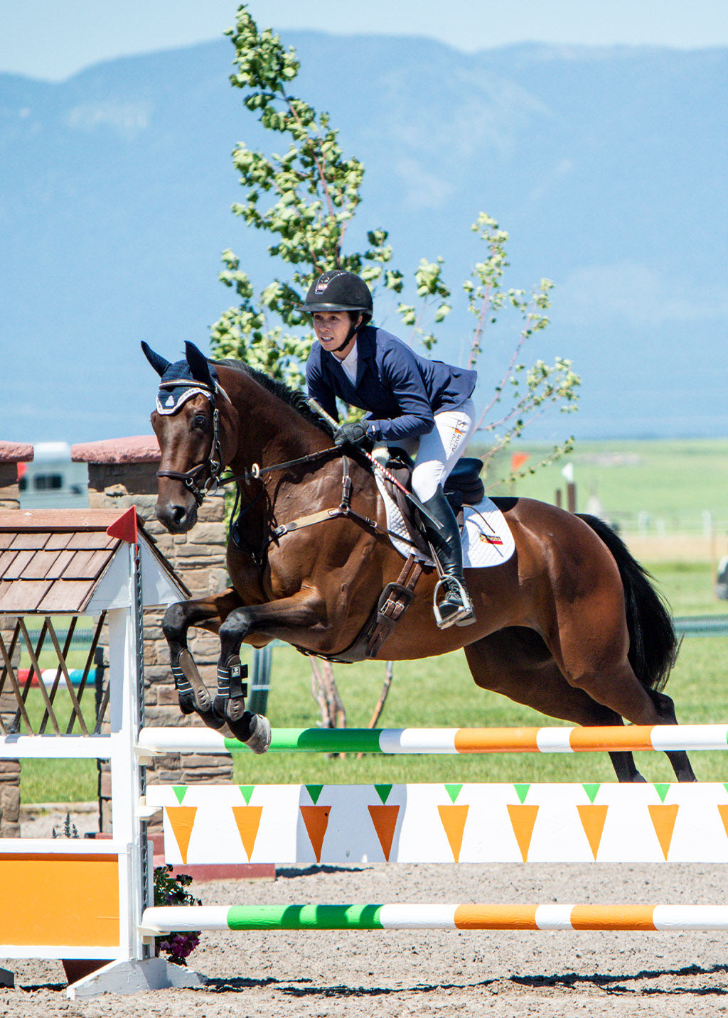 Equestrian wearing the Stretch Competitor Koat while riding, demonstrating the coat's flexibility and elegant appearance in the saddle