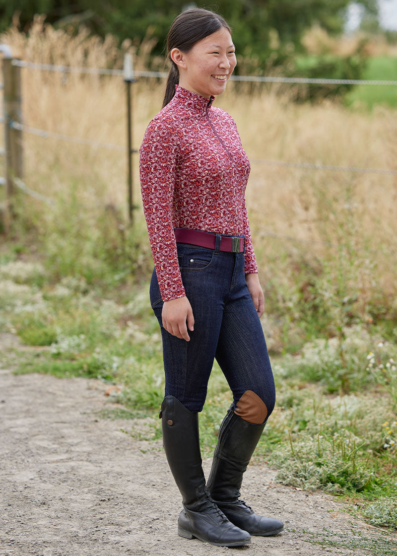 Rider standing wearing the breech, highlighting the traditional denim look with equestrian functionality.