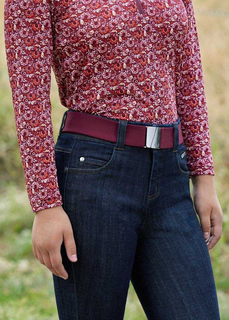 Close-up of the rider's waist area, highlighting the belt's design and the Kerrits logo on the buckle