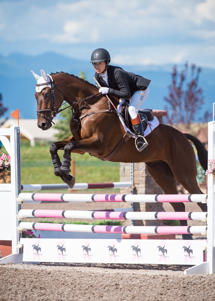 Equestrian wearing the Stretch Competitor Koat while riding, demonstrating the coat's flexibility and elegant appearance in the saddle