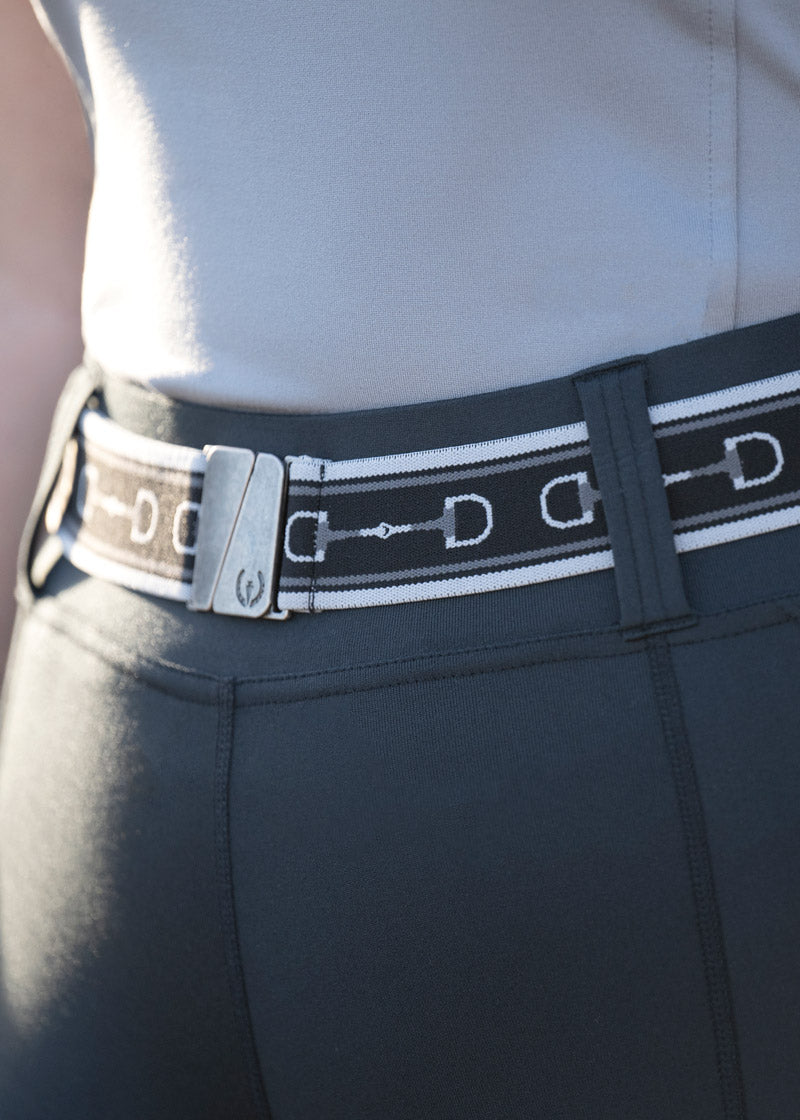 Rider wearing te Snaffle Stretch Belt in Dapple/Black, showing a closeup of the snaffle print and closure.