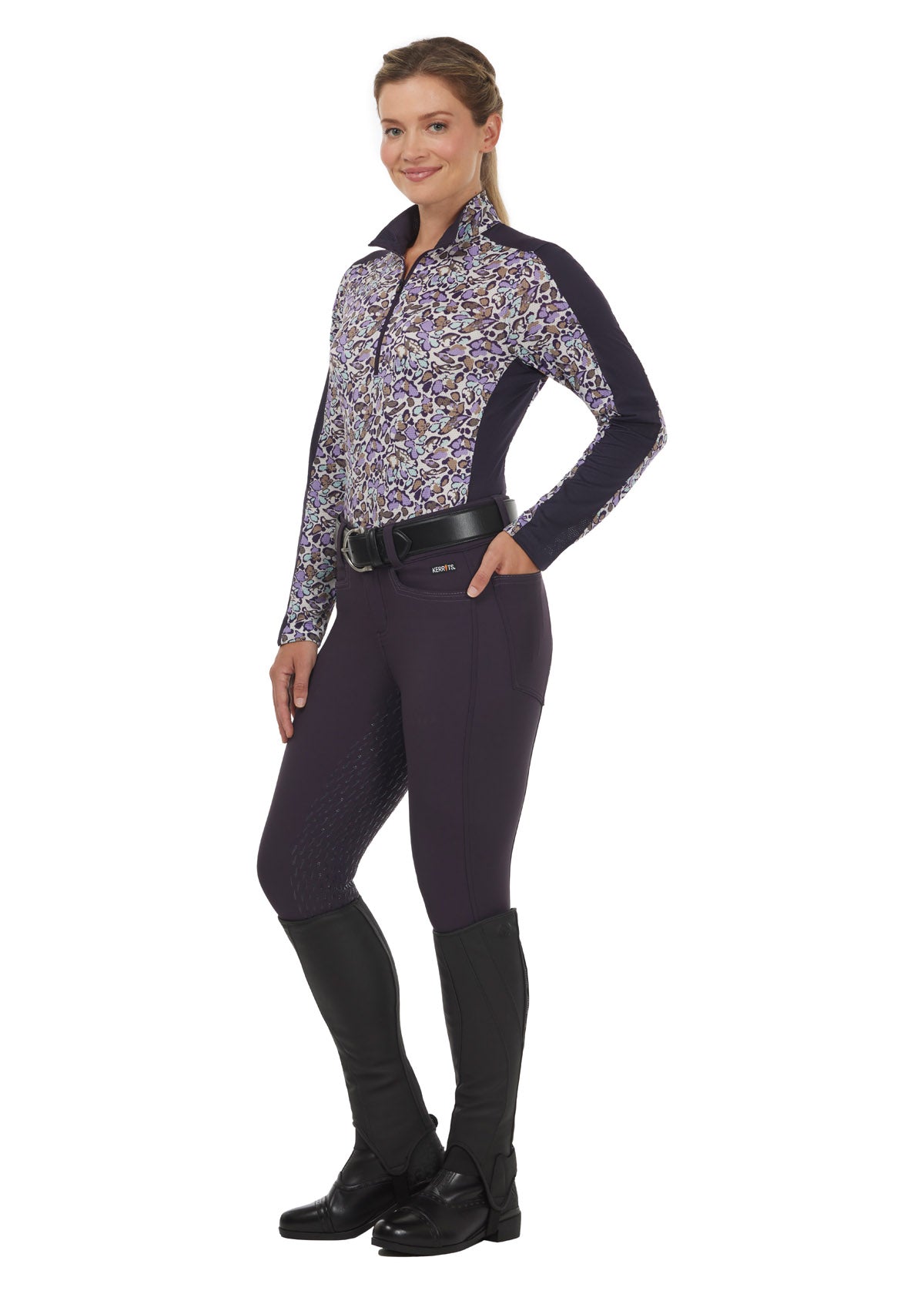 Model wearing the Breeze Ice Fil® Long Sleeve Riding Shirt in Orchid Springtime print, paired with purple breeches for a stylish summer equestrian outfit.