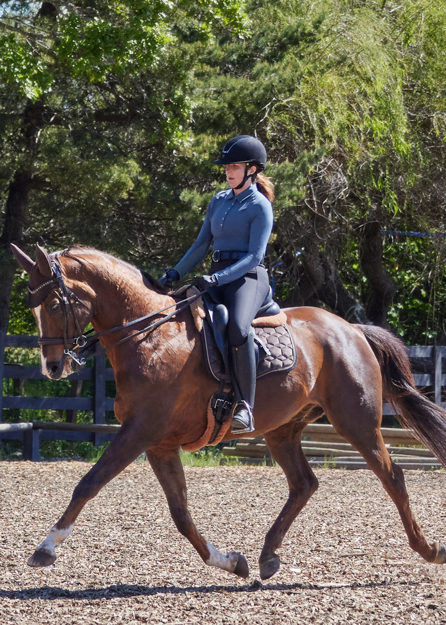 Individual wearing the Kerrits In a Snap Long Sleeve Equestrian Clinic Shirt during a training session, showcasing its performance features and comfort.
