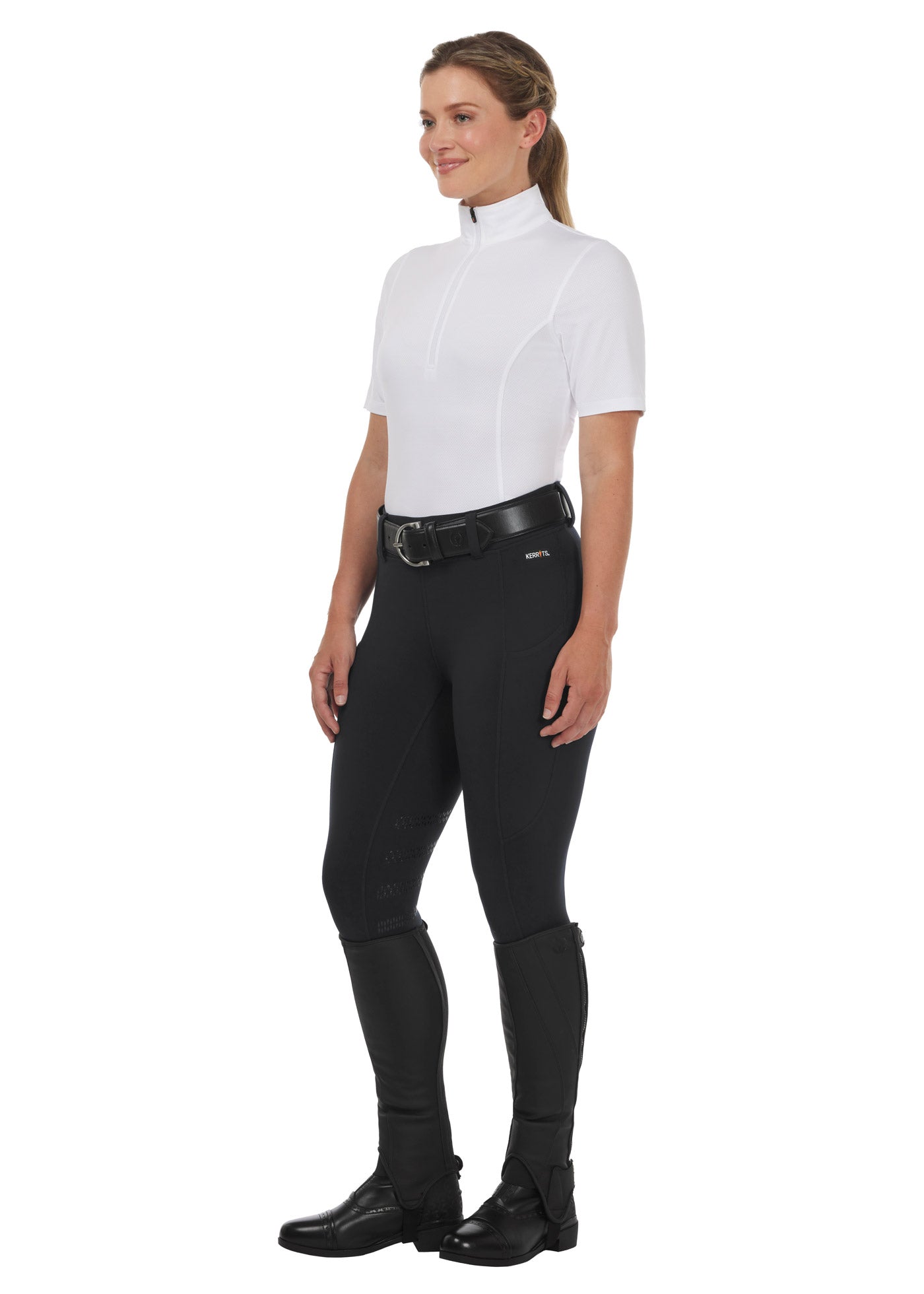 Rider wearing the Kerrits Ice Fil® Lite Short Sleeve Riding Shirt in white, paired with black riding tights for a polished equestrian look.