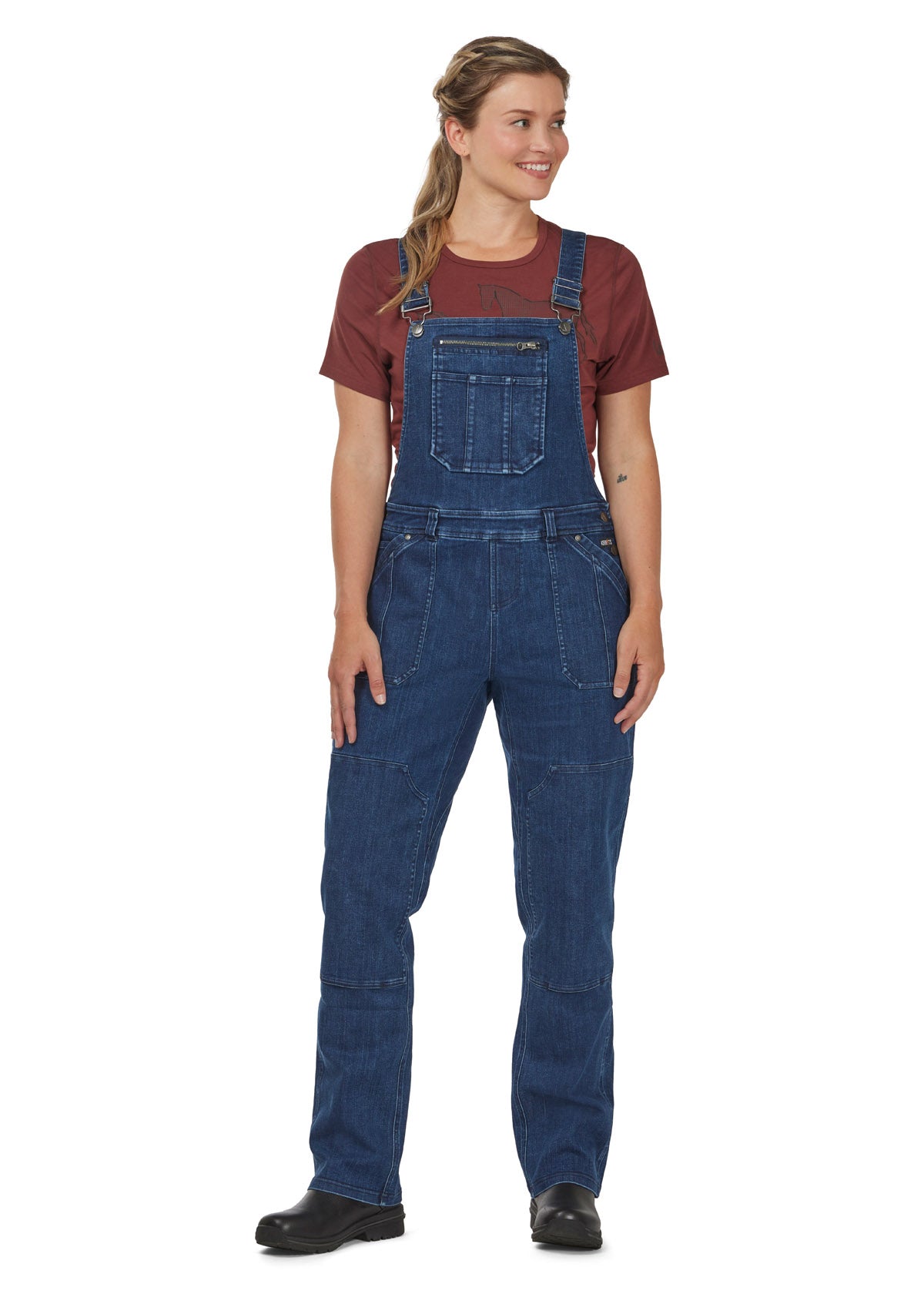 Front view of the Kerrits Stable Hand Stretch Denim Barn Overalls in denim, showcasing the adjustable suspenders and multi-function chest patch pocket with secure zip