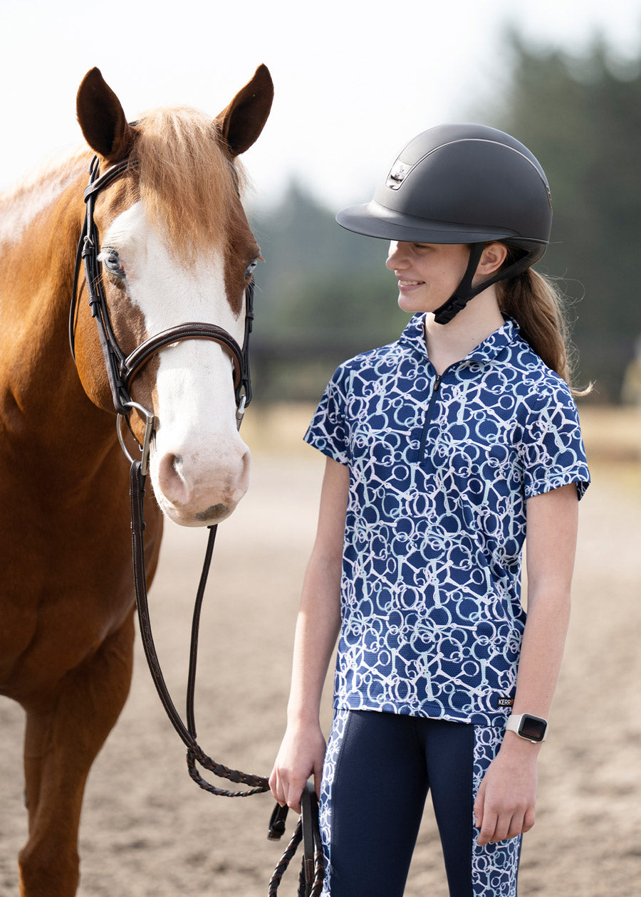 Rider standing beside a horse, dressed in the shirt, highlighting the blend of performance and style suitable for various equestrian activities