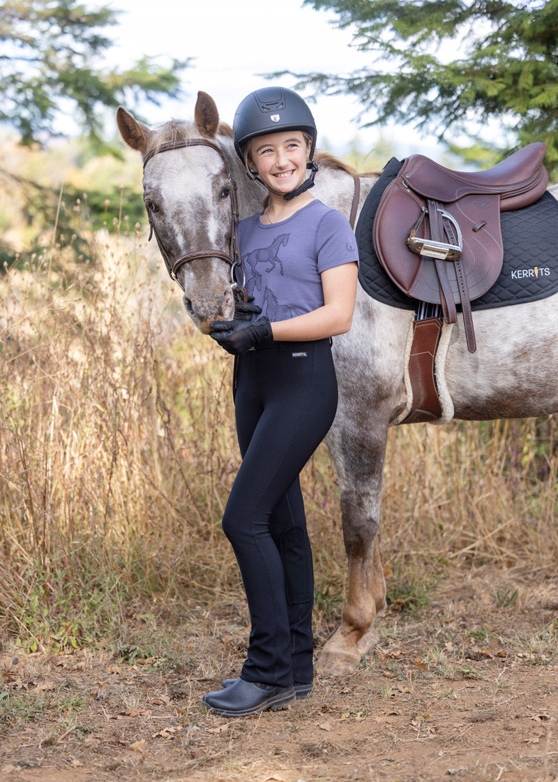 Rider standing beside a horse, dressed in the Microcord™ Bootcut Riding Pant, highlighting the professional and stylish appearance suitable for competitions