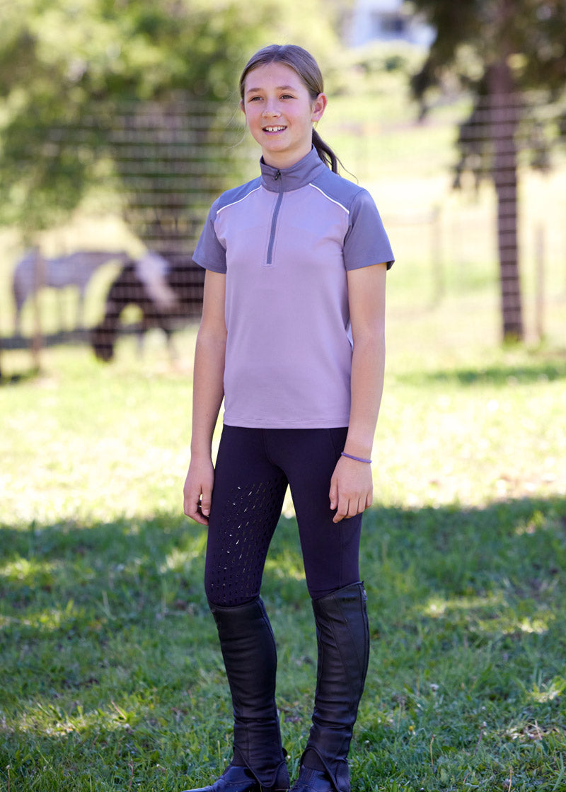 Child wearing the riding tights outside highlighting the durable and moisture-wicking properties of the Coolcore® fabric